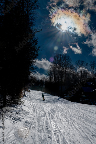 Snowboarder coming down trail photo
