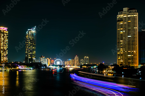 Night light landscape along the Chao Praya River, having some boats come to celebrate the New Year eve on the Asiatique landmark side in Bangkok city, Thailand. © Bobbyphotos