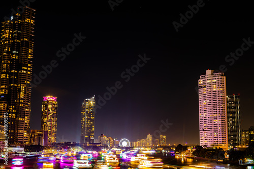 Night light landscape along the Chao Praya River, having some boats come to celebrate the New Year eve on the Asiatique landmark side in Bangkok city, Thailand. photo