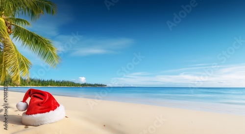 Santa Claus hat on the beach with palm tree and blue sky background