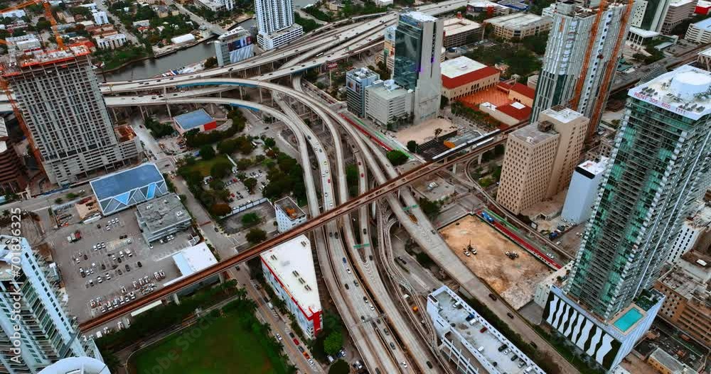 Cars move by the multiple freeways in the metropolis downtown. Cityscape of Miami, Florida, USA from top.