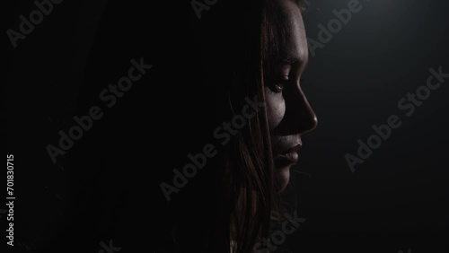 Sad young woman in the dark photo