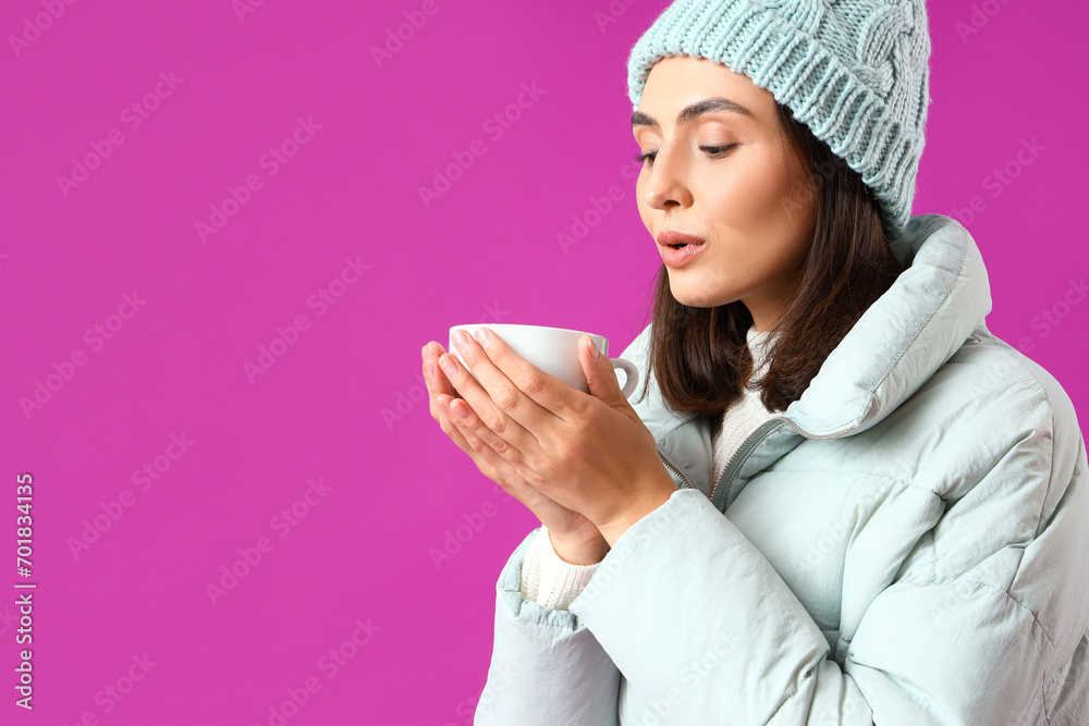 Young woman in winter clothes with cup of hot tea on purple background, closeup Young woman in winter clothes with cup of hot tea on purple background, closeup