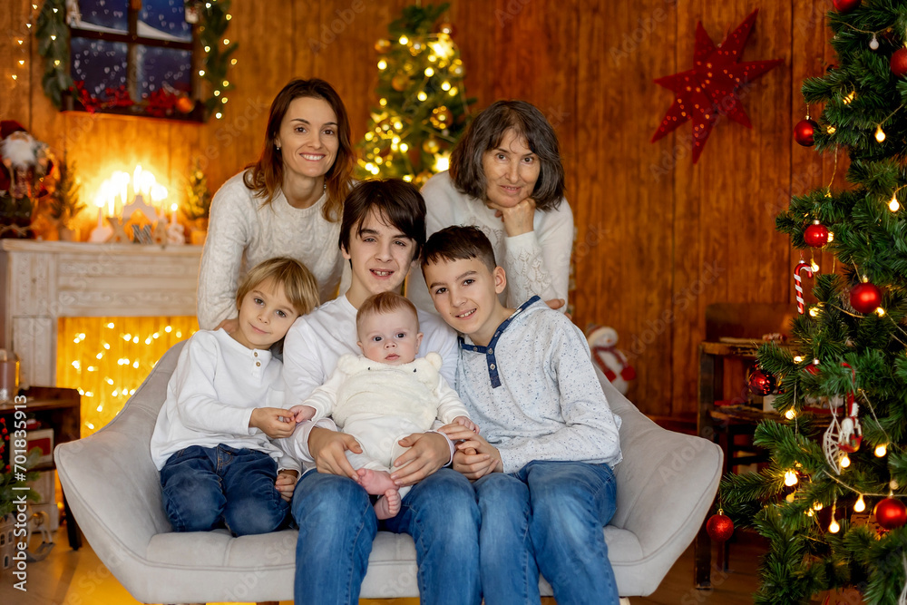 Happy family, newborn baby and older brothers, mom at home on Christmas