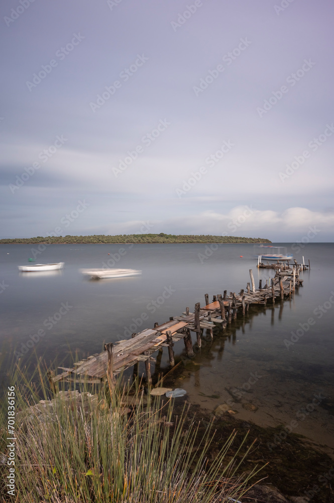 wooden pier by the sea blue water and clouds in the sky wooden pier by the sea blue water and clouds in the sky