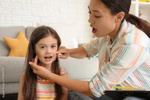 Foto Female Asian speech therapist working with little girl in office