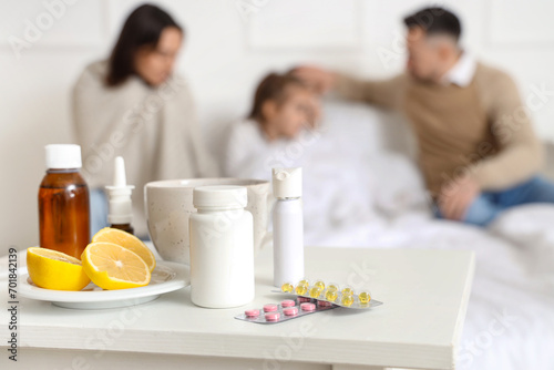 Medications with lemon on table of ill family in bedroom, closeup