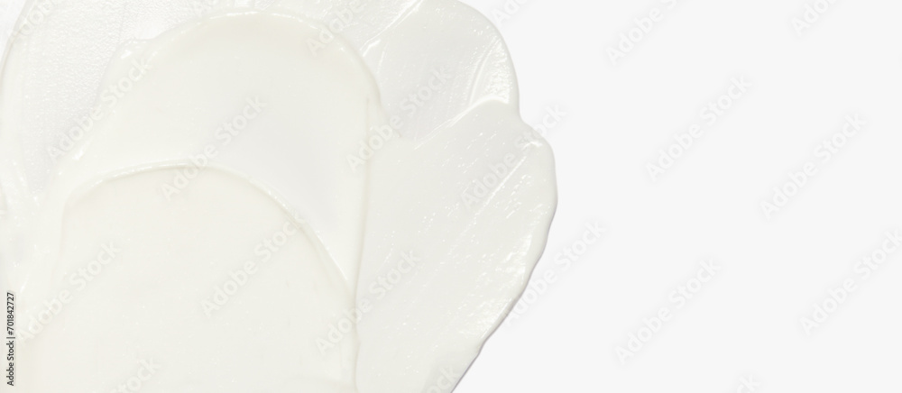 White cosmetic cream smeared on a white background.