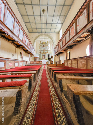 Interior view of the church with wooden benches with red velvet coverings and an old altar with an organ in the Biserica Evanghelica Fortificata Viscri, Deutsch-Weisskirch, Brasov, Transylvania, Roman photo