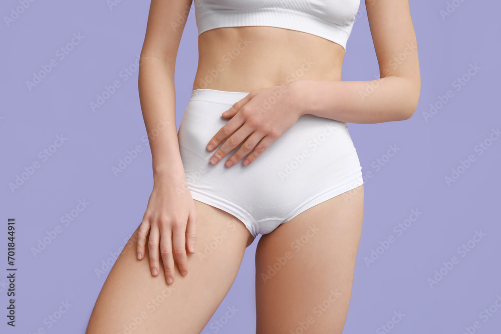 Beautiful young woman after depilation of legs on purple background, closeup
