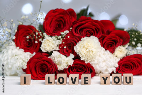 Bouquet of beautiful flowers and text I LOVE YOU on white wooden table