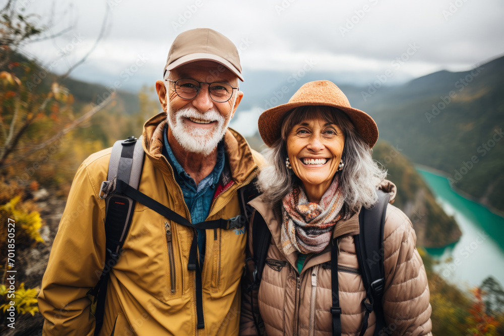 Senior couple hiking in mountains. Elderly tourists with backpacks travelling outdoor. Active lifestyle in old age
