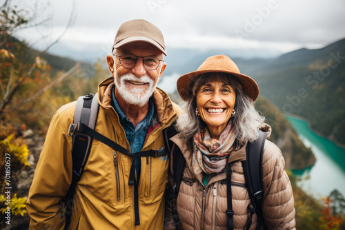 Senior couple hiking in mountains. Elderly tourists with backpacks travelling outdoor. Active lifestyle in old age