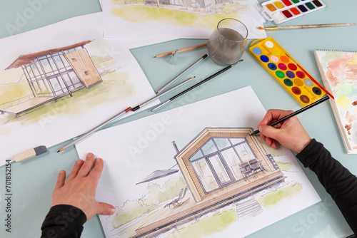 Architect illustrator working on hand drawn illustration of a modular house  using black pencil to draw lines on a sketch. photo