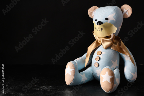 Toy bear with taped mouth a...