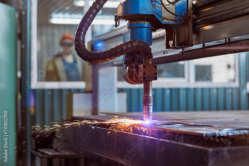 CNC laser plasma. Selective focus on modern technology laser plasma cutting of metal in process at metalworking factory male worker on background copyspace