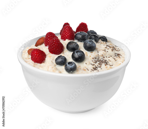 Tasty boiled oatmeal with berries, almonds and chia seeds in bowl isolated on white