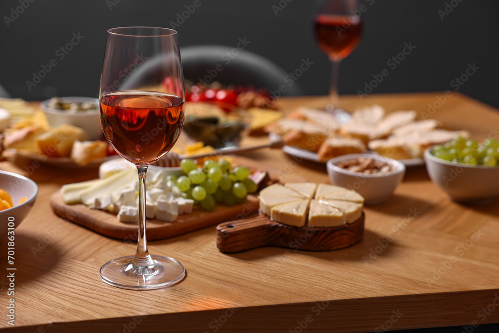 Rose wine and appetizers served on wooden table, selective focus. Space for text