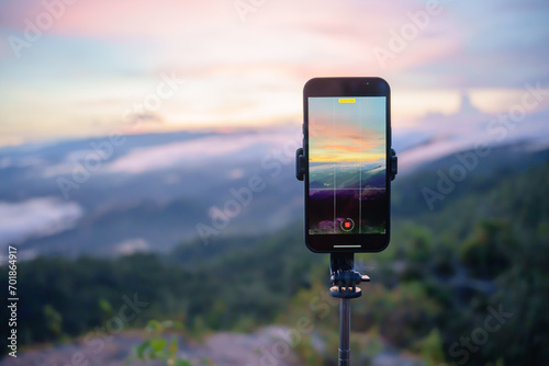 Smartphone Taking photo of mountain stream with  tripod nature view on screen at sunset