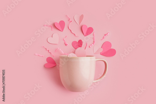 Cup with hearts and shredded paper on pink background. Valentine s Day celebration