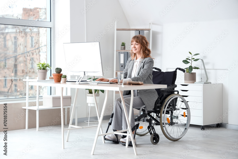 Young businesswoman in wheelchair working with computer at office Young businesswoman in wheelchair working with computer at office
