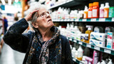 Old lady concerned with high food prices and inflation in pharmacy