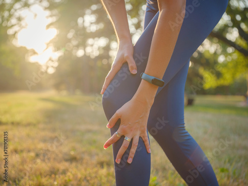 Canvas Print woman with knee pain in evening park