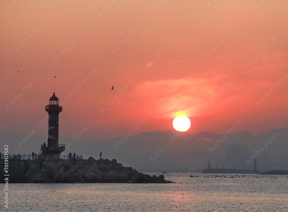 Lighthouse and sun taken from the sea at sunrise