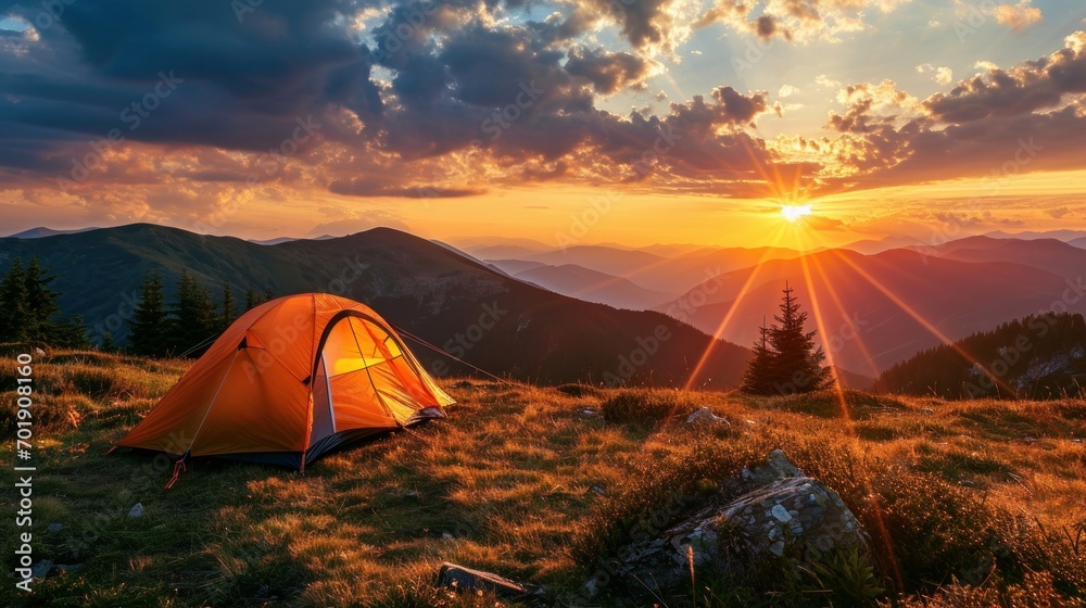Glowing orange tent in the mountains under dramatic evening sky