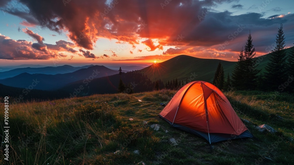 Glowing orange tent in the mountains under dramatic evening sky Glowing orange tent in the mountains under dramatic evening sky