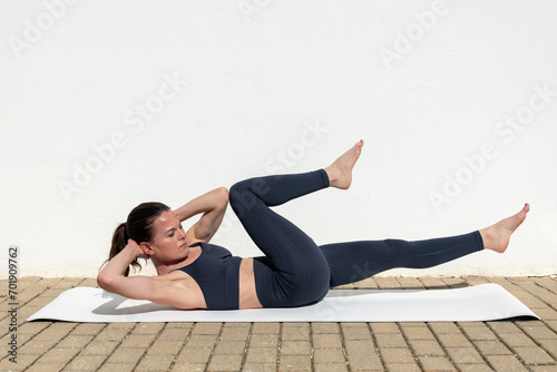 Fit, sporty woman doing bicycle crunch workout to improve her abominal muscles.