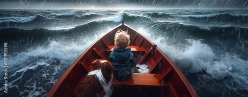 A young boy or toddler and a dog in a small rowboat try to navigate stormy seas during a thunderstorm in the middle of the ocean with giant waves photo