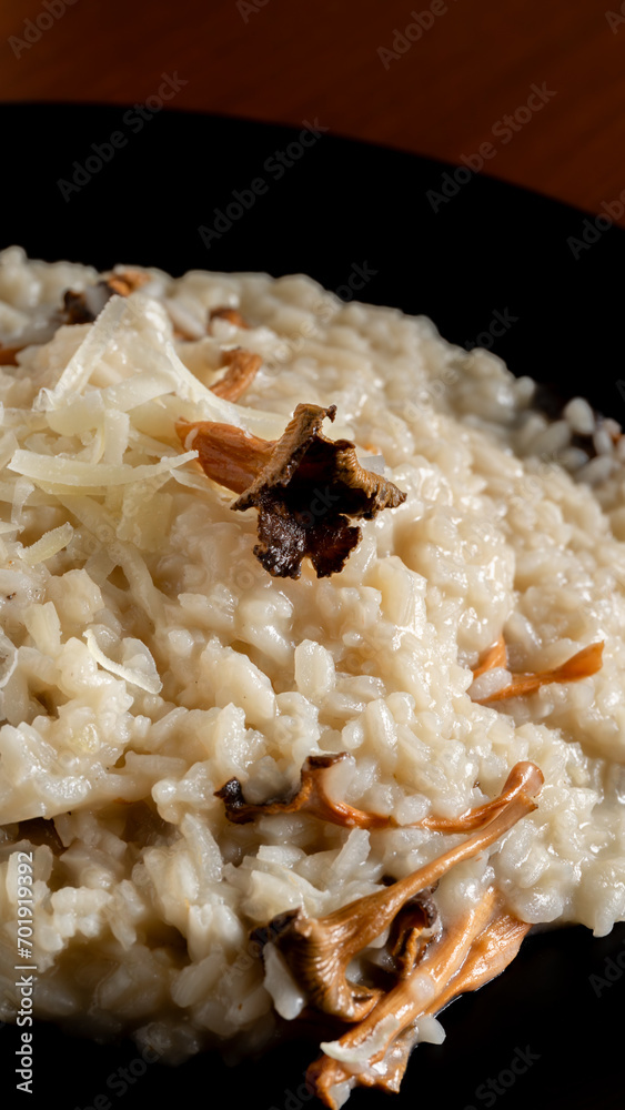 Vertical photo detail, creamy risotto with wild trumpets and parmesan. Food and gastronomy concept. Vertical photo detail, creamy risotto with wild trumpets and parmesan. Food and gastronomy concept.