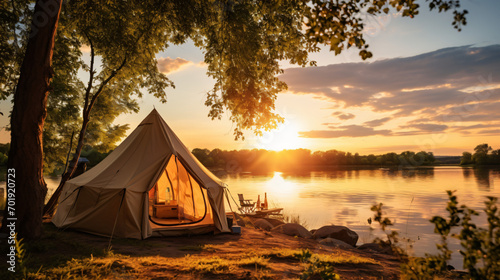 A tent is set up on the bank of a river