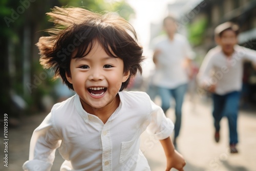 happy asian child boy running on the background of a crowd of people