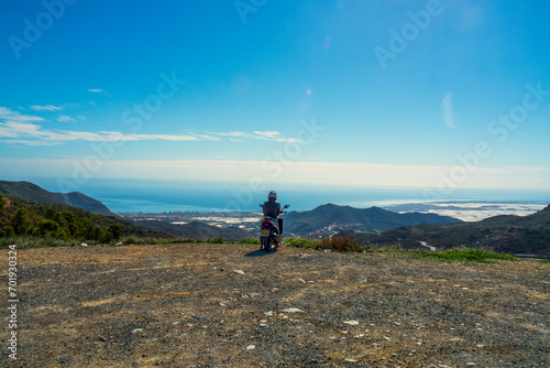 Hombre con moto mirando el paisaje en la costa de Almería, España © Juanmi