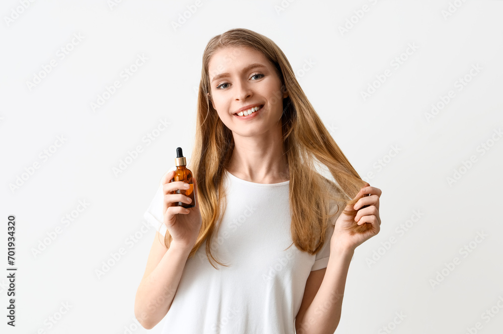 Young woman with serum for hair growth on light background Young woman with serum for hair growth on light background
