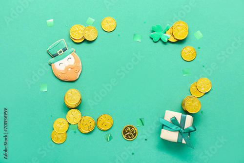 Frame made of cookie, golden coins and gift on green background. St. Patrick's Day celebration