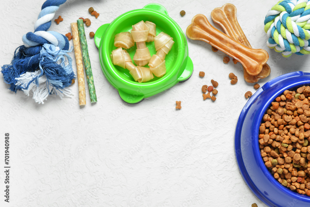 Composition with different dog food and toys on light background Composition with different dog food and toys on light background