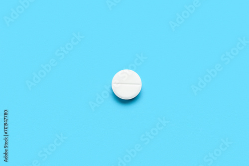 White medical pill on blue background