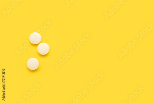 White medical pills on yellow background