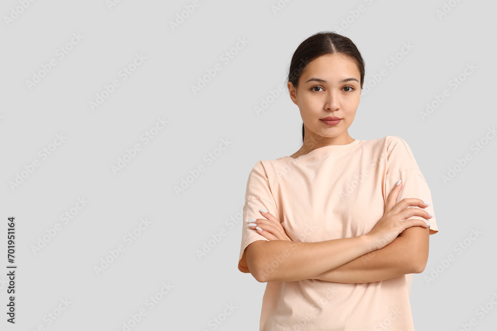 Confident young woman with crossed arms on white background. Feminism concept Confident young woman with crossed arms on white background. Feminism concept