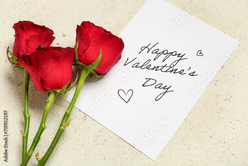 Card with text HAPPY VALENTINE'S DAY and red roses on light grunge background
