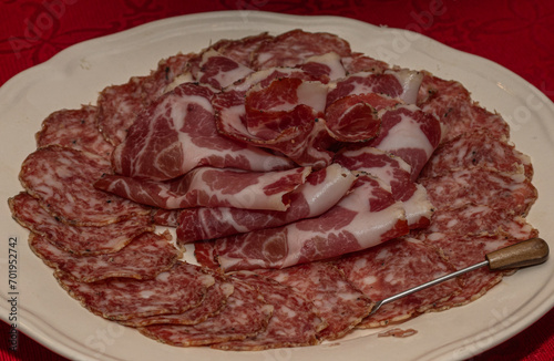 Sliced Salami and Soppressata Arranged on White Plate over Red Tablecloth