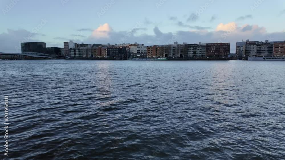 View over IJhaven river in Amsterdam shot from Veemkade, showing the skyline of Javakade at Java-eiland during sunset, panning shot View over IJhaven river in Amsterdam shot from Veemkade, showing the skyline of Javakade at Java-eiland during sunset, panning shot