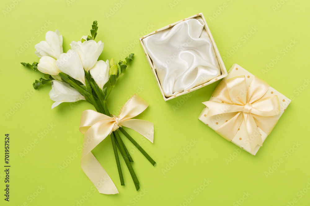Open gift box, with fresia flower color background, top view Open gift box, with fresia flower color background, top view