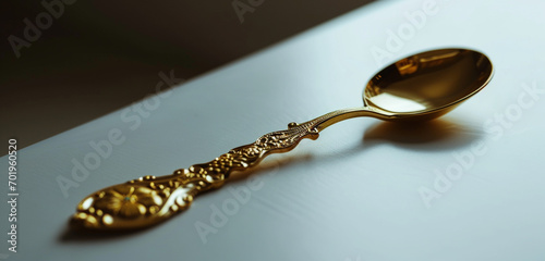 Ornate golden spoon on a minimalist white backdrop, a statement of elegance.