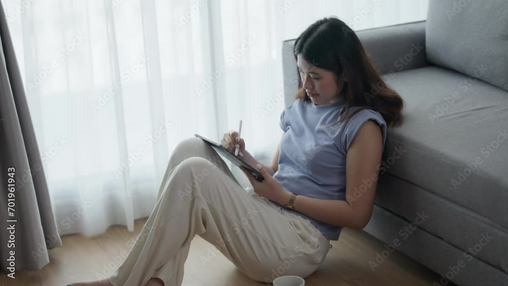 Asian woman using tablet writing ideas and memo at her home. Asian woman using tablet writing ideas and memo at her home.