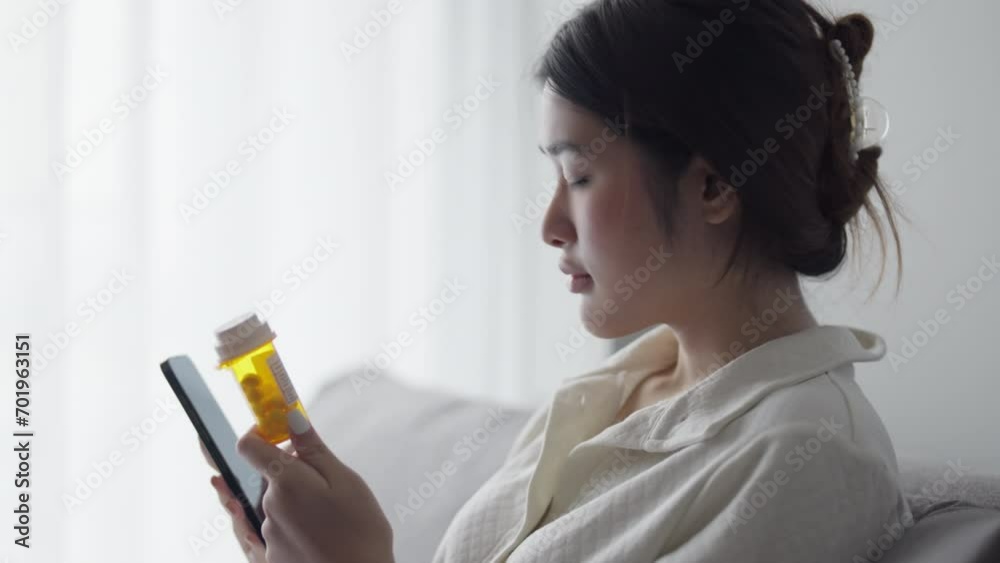 woman holding prescription pill bottles and using smartphone searching online information about medicament woman holding prescription pill bottles and using smartphone searching online information about medicament