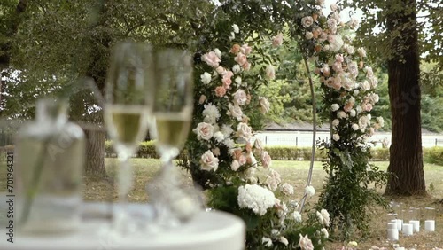 wedding arch of white rose flowers on the river bank before the wedding ceremony of the bride and groom, festive romantic decor photo
